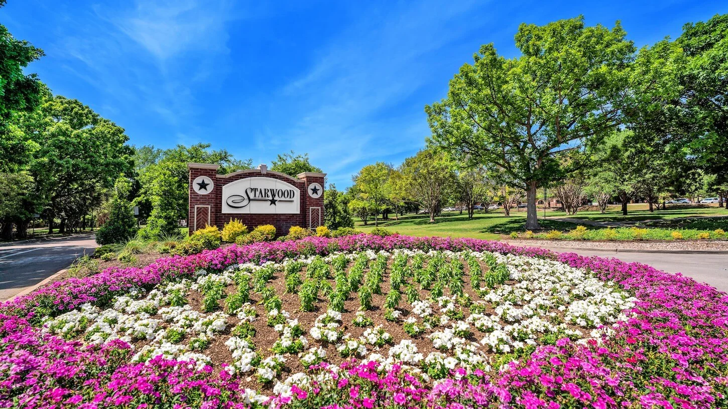 Landscaped Starwood community entrance with flowers and entry sign