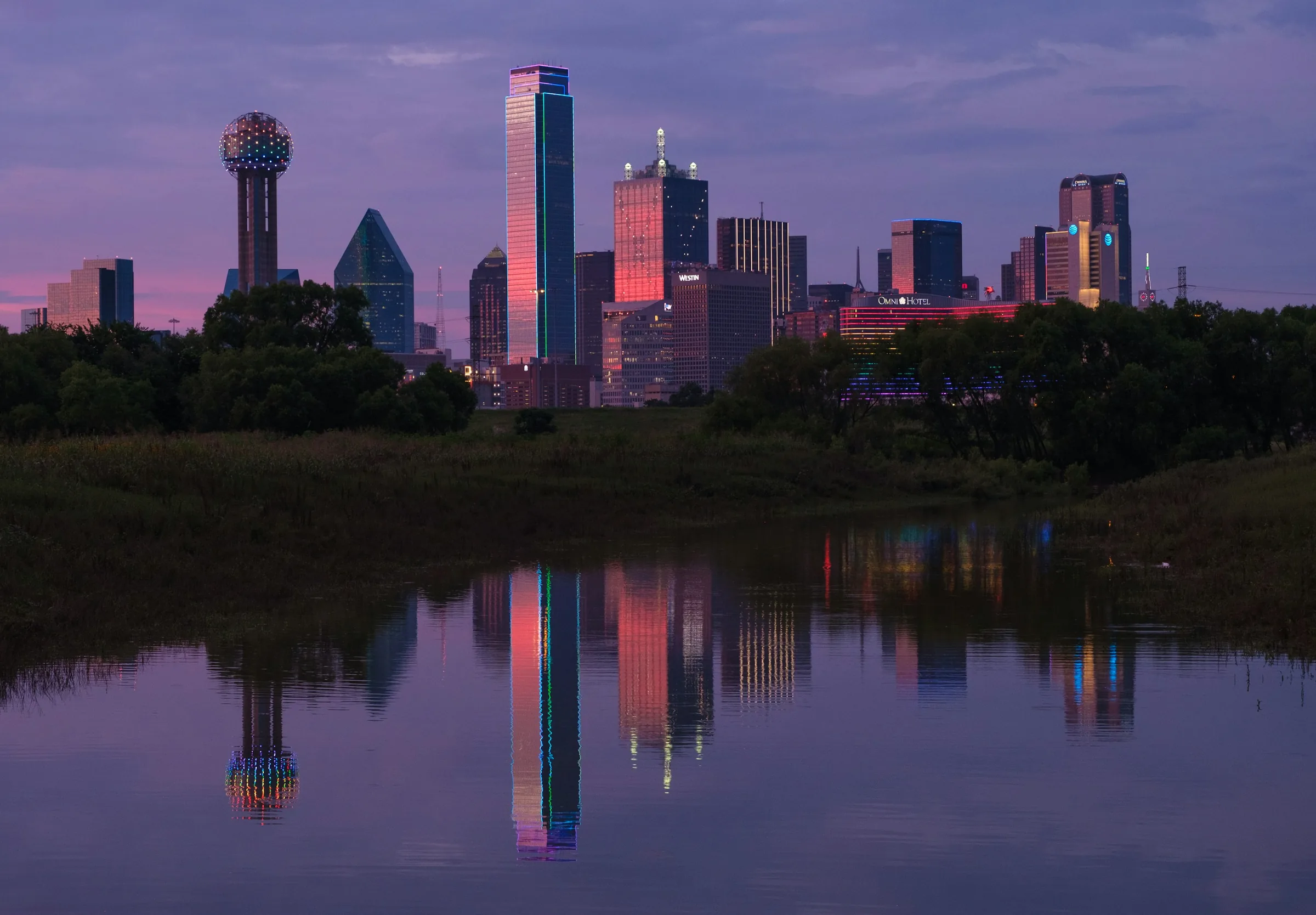 Downtown Dallas skyline at dusk across the Trinity River